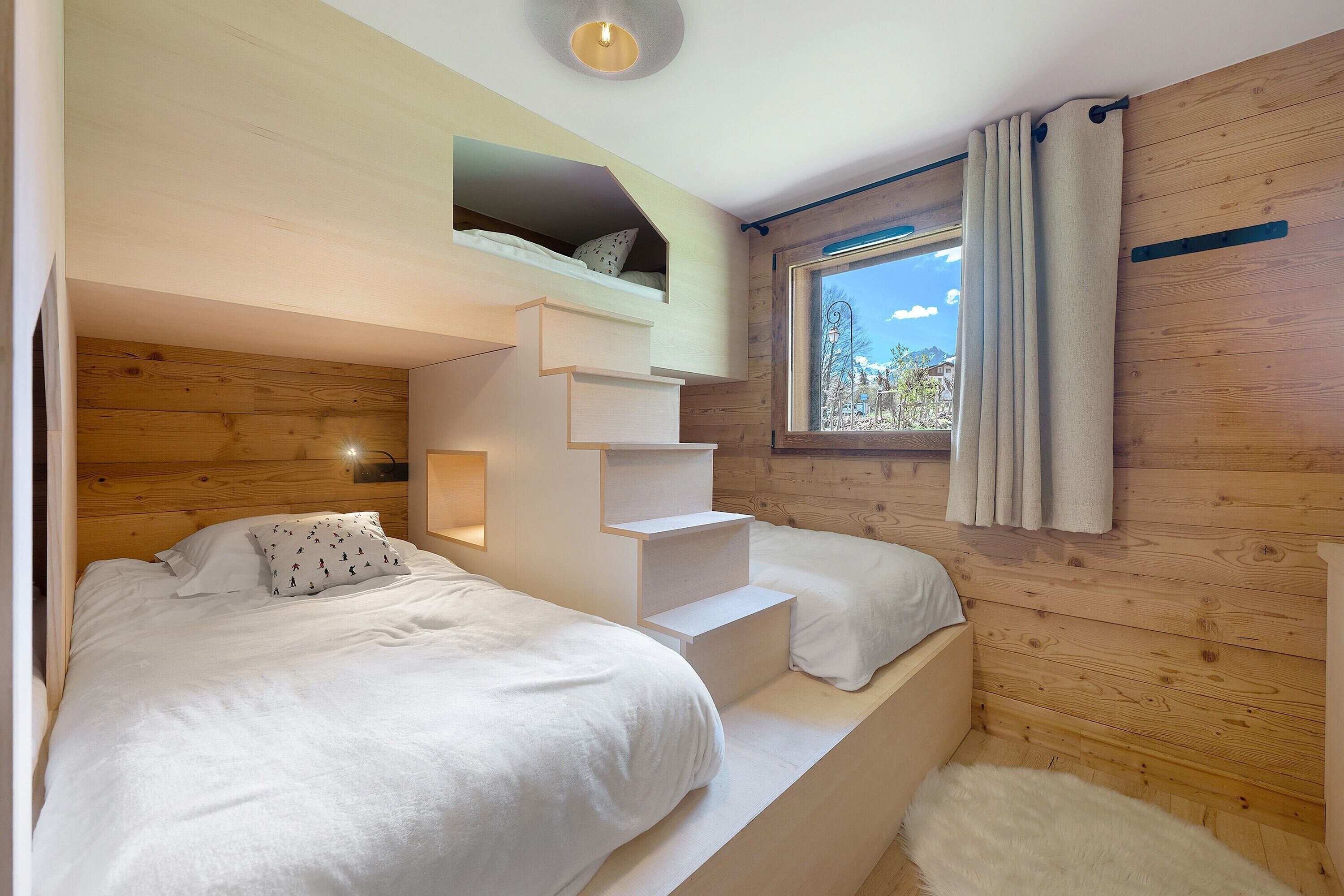 Ein Schlafzimmer mit Etagenbett, einem Fenster mit Vorhängen und einer Holzwand.