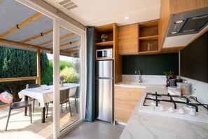 Eine moderne Küche mit einem Edelstahl-Kühlschrank, einem Gasherd und Holzschränken.