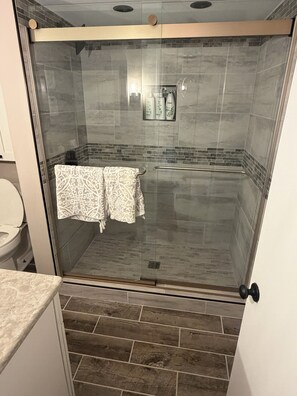 Een douche, handdoeken, zeep, toiletpapier