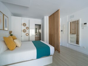 A bedroom with a bed, a wardrobe, a bathroom, and a sliding door. - Sunset Loft By CanariasGetaway (Mogán)