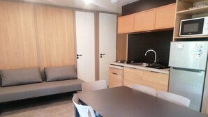 Una cocina compacta con una mesa y sillas, un sofá y un microondas.