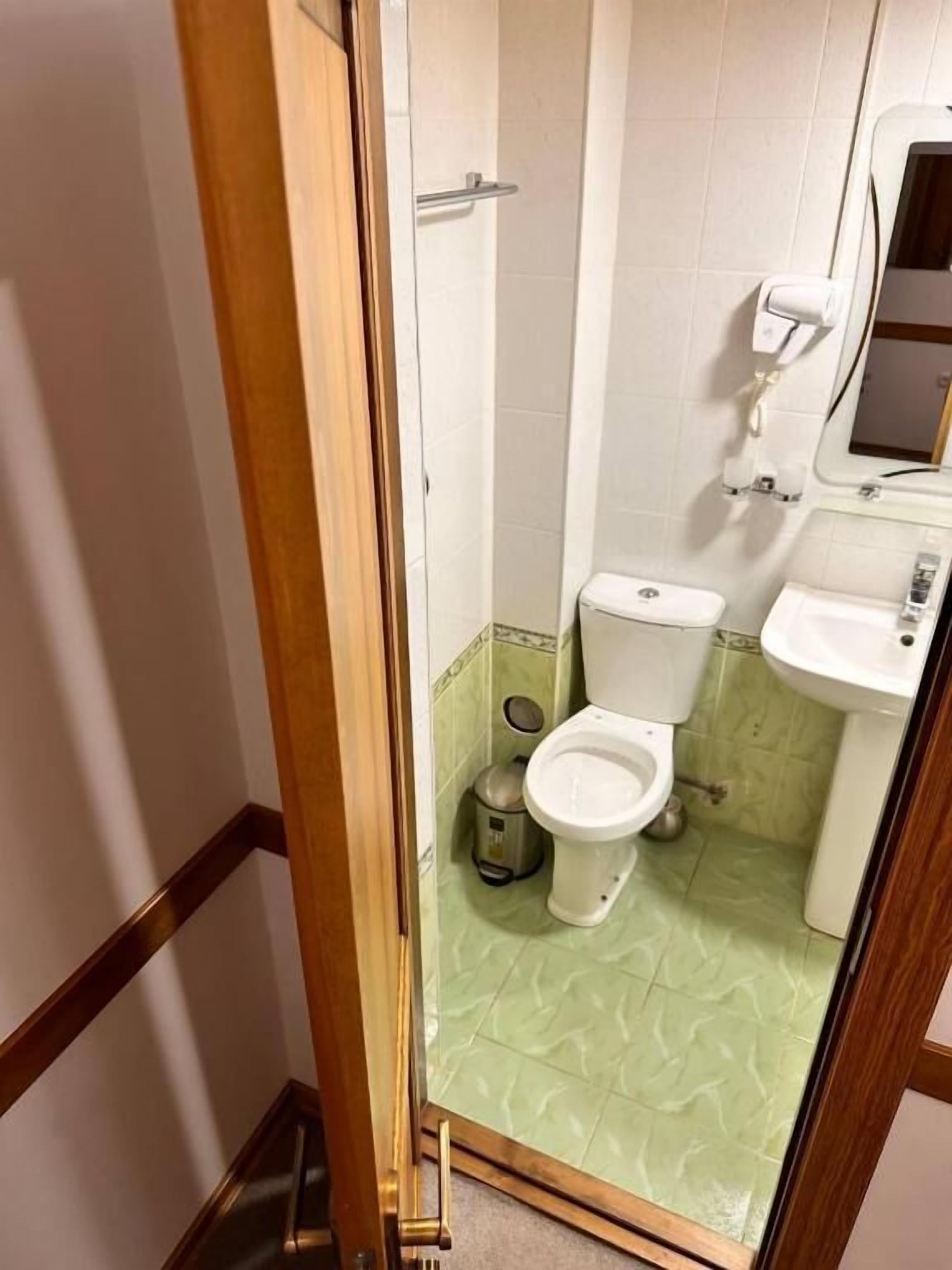 A bathroom with a toilet, sink, and shower.