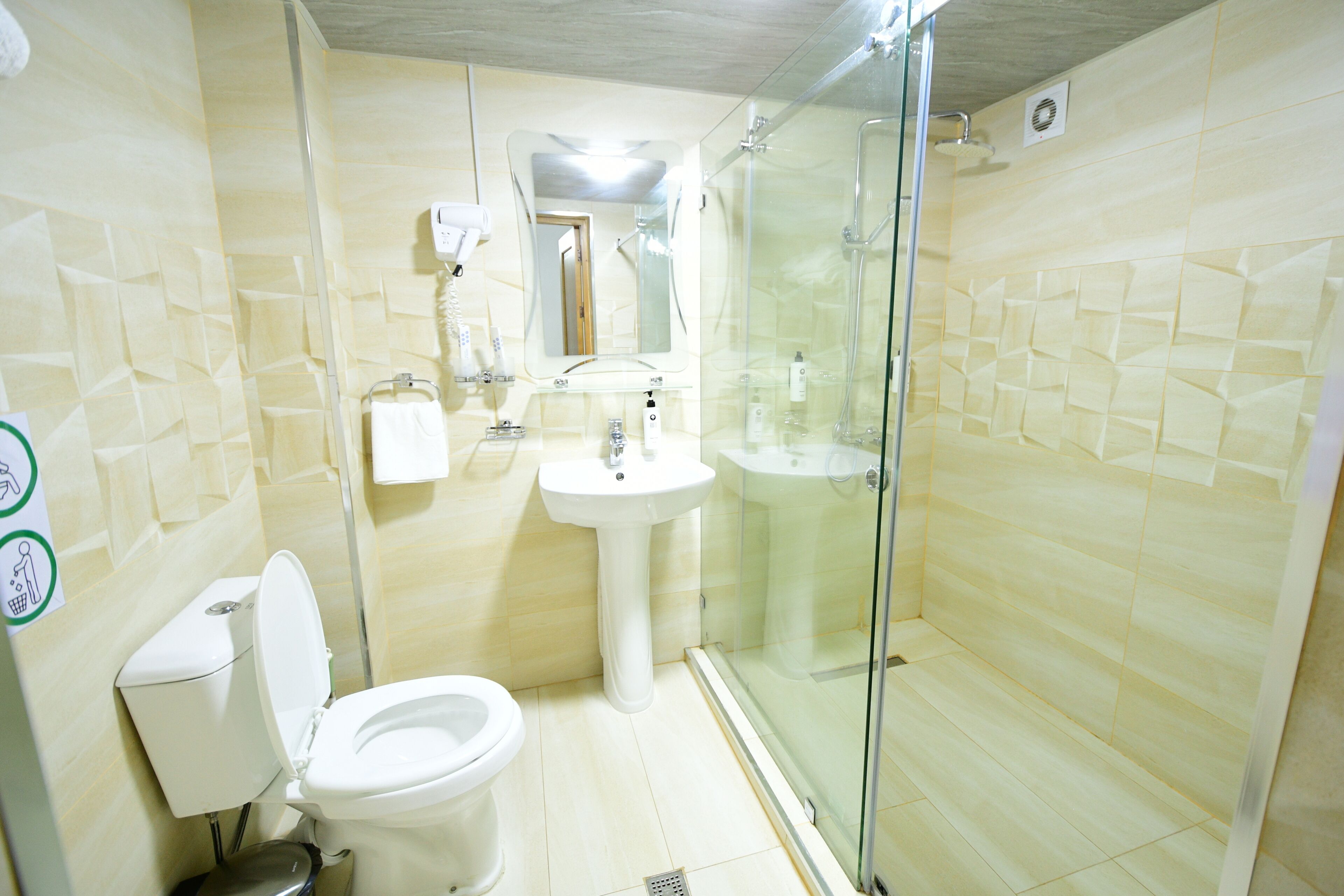 A bathroom with a toilet, sink, and glass-enclosed shower.