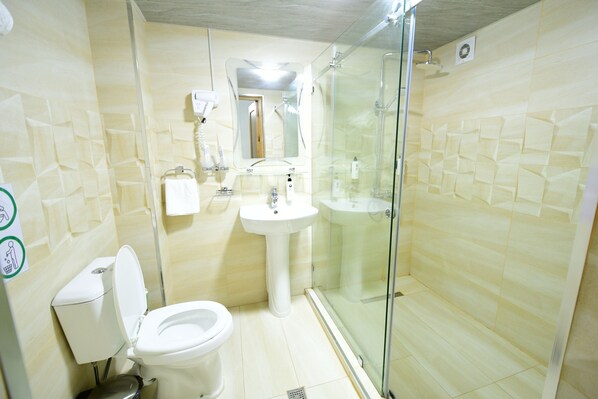 A bathroom with a toilet, sink, and glass-enclosed shower.