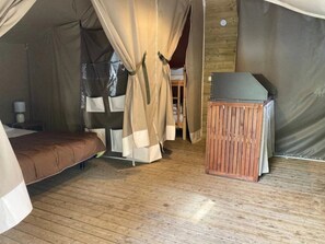 Ein Zeltraum mit Bett, einem kleinen Tisch und einem Stuhl.