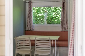 Ein Zimmer mit Fenster, Tisch und zwei Stühlen.