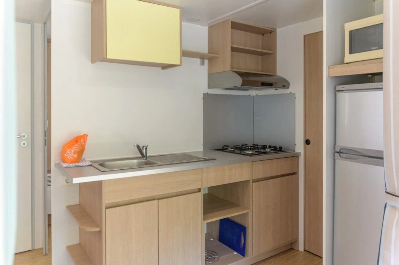 Eine kleine Küche mit Spüle, Herd und Kühlschrank.