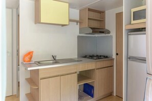 A compact kitchen with a sink, stove, and a refrigerator. - Camping 2 étoiles - Piscine  - ccbgbhe (Sospel)