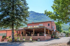 Ein Gebäude mit einem Restaurantschild, Außenbereich und einem Berg im Hintergrund.