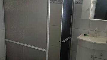 Chuveiro, toalhas de banho, sabonete, papel higiênico