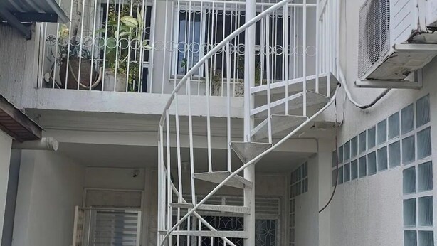 A white multi-level building with a spiral staircase, potted plants, and a door. - Simplicity and Prime Location in Manaus. (Manaus)