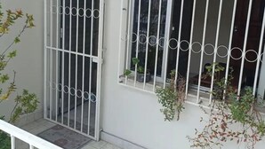 A gated balcony with a tiled floor, a white railing, and potted plants. - Simplicity and Prime Location in Manaus. (Manaus)