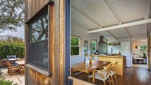 A modern kitchen with a central island, wooden dining table, and chairs.