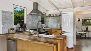 A modern kitchen with a central island, a built-in stove, and a stainless steel range hood.