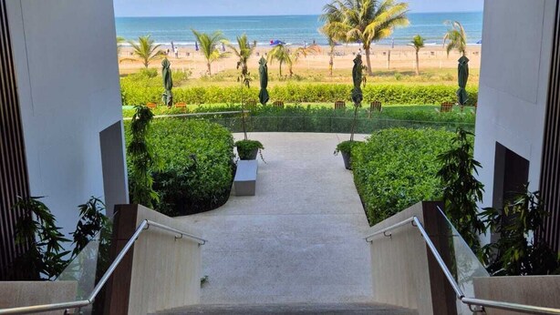 A staircase leading to a balcony with a view of a beach and palm trees. - MODERN APT WITH SEA VIEW AND SWIMMING POOLS 1 BEDROOM WITH BALCONY. MANZANILLO BEACH. (CARTAGENA)