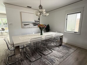 A dining area with a long table, clear chairs, a vase with flowers, a painting on the wall, and a window. - Rabelo’s House
Awesome 5-bedroom house with AC in charming Tampa (Tampa)