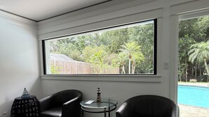 A room with a large window, two black leather chairs, a small glass table, and a bookshelf. - Rabelo’s House
Awesome 5-bedroom house with AC in charming Tampa (Tampa)