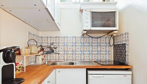 Eine kleine Küche mit Mikrowelle, Spüle und Geschirrspüler von Bosch.