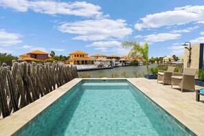 A swimming pool with a view of a marina and buildings. - Blue Lagoon with a lovely private pool and views over the lagoon (Kralendijk)