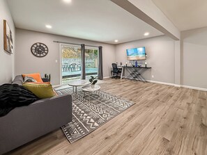 Een moderne woonkamer met een bank, salontafel en televisie.