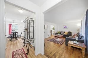 Ein geräumiges Wohnzimmer mit einer Couch, einem Couchtisch und einer Glastrennwand.