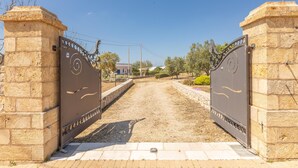 A gated entrance with a paved path leading to a building. - Villa Miravalle - Salve (Salve)
