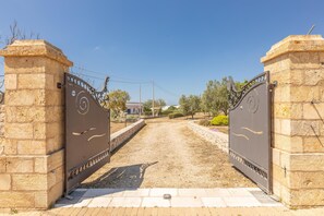 A gated entrance with a paved path leading to a building. - Villa Miravalle - Salve (Salve)