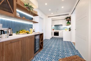 A modern kitchen with wooden cabinets, a white countertop, and blue patterned flooring. - AMORE RENTALS - Apartment Seapearl Sorrento with Sea View, Near the Beach (Sorrento)