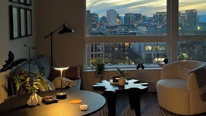 A modern living room with a large window, a round coffee table, a sofa, and a lamp. - Cozy 1-bedroom apartment with AC in vibrant Seattle neighborhood (Seattle)