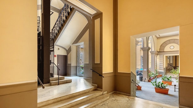 A marble staircase leading to a second-floor landing with a view of a courtyard. - Apartment 'Deluxe Con Balcone' with Balcony, Wi-Fi and Air Conditioning (Napoli)