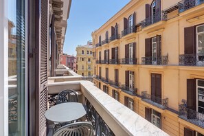 Ein mehrgeschossiges Gebäude mit Balkonen, einer Marmor-Brüstung und Blick auf die Nachbargebäude.