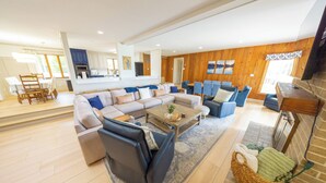 Een moderne woonkamer met een hoekbank, een salontafel en een open haard.