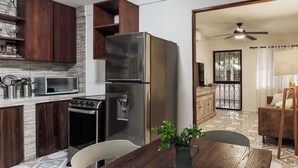Une cuisine moderne équipée d’un réfrigérateur, d’une cuisinière, d’un four à micro-ondes et de meubles de rangement en bois.