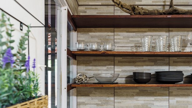 Une cuisine avec des étagères en bois, de la verrerie et un coquillage décoratif.