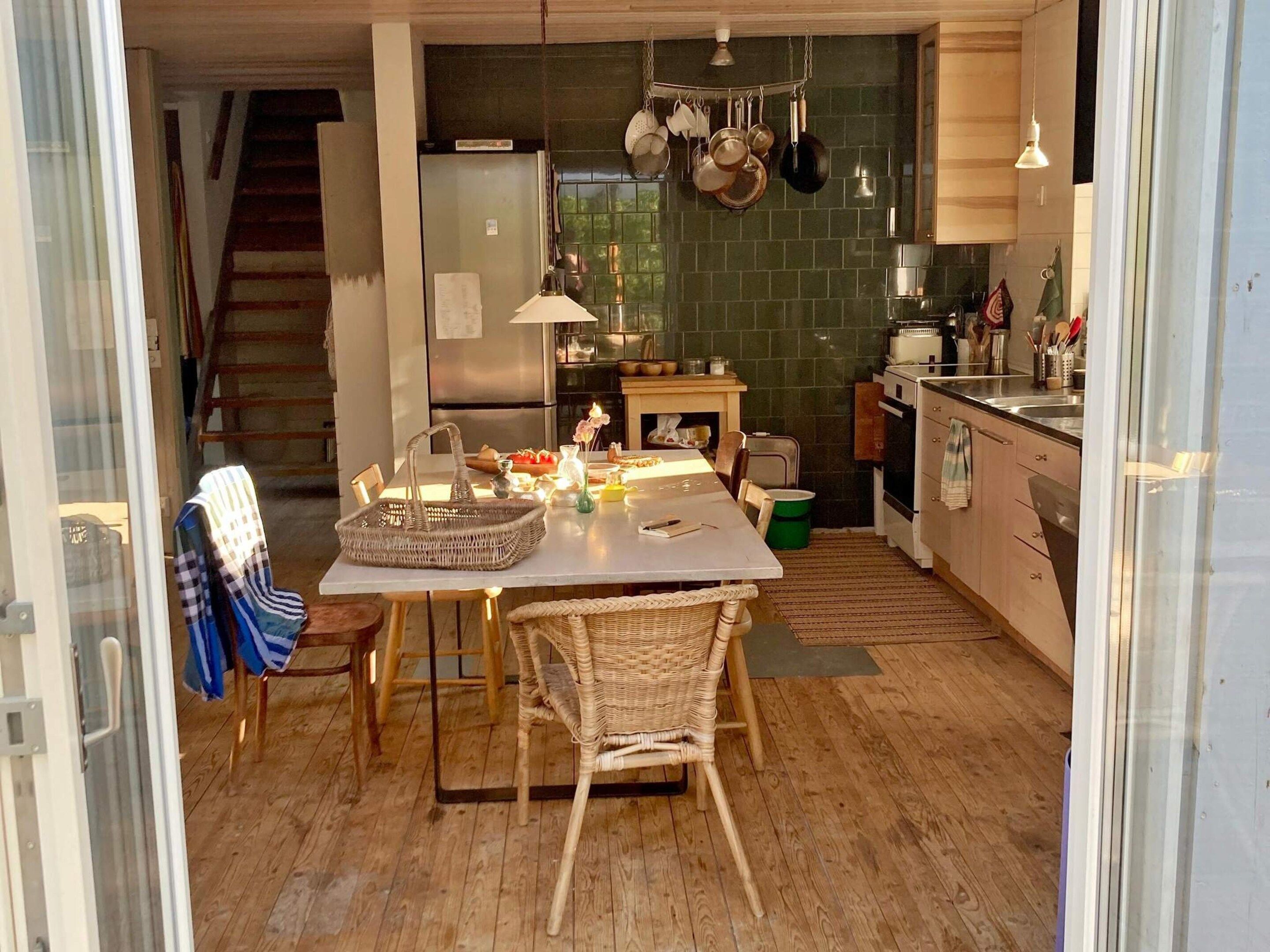 A cozy kitchen with a dining table, chairs, and a variety of kitchen utensils.