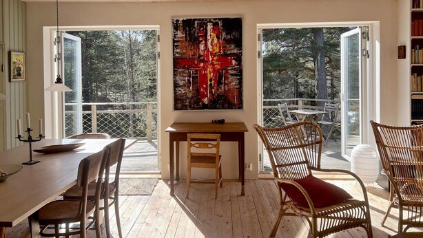 A room with a dining table, chairs, a painting, and large windows. - 4 Star Holiday Home in Runmaro (Runmaro)