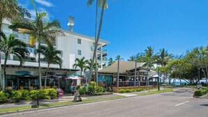 A hotel with a modern design, featuring a prominent white facade, multiple balconies, and a view of the ocean. - Drift into Paradise: Exceptional Resort Living (Palm Cove)