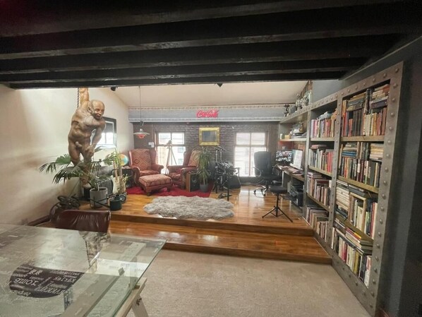 A room with a glass table, a sofa, a bookshelf, and a statue. - Cosy American Style apartment (Liverpool)