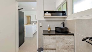 Una cucina moderna con un piano di lavoro nero, un armadietto in legno e un lavello nero.