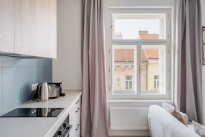 Eine moderne Küche mit Fenster, Heizkörper und einer Couch.