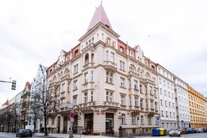 Ein großes, historisches Gebäude mit einem markanten Eckturm und zahlreichen Fenstern.