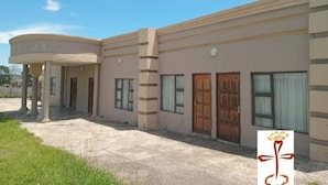 A building with a curved entrance, multiple windows, and doors.
