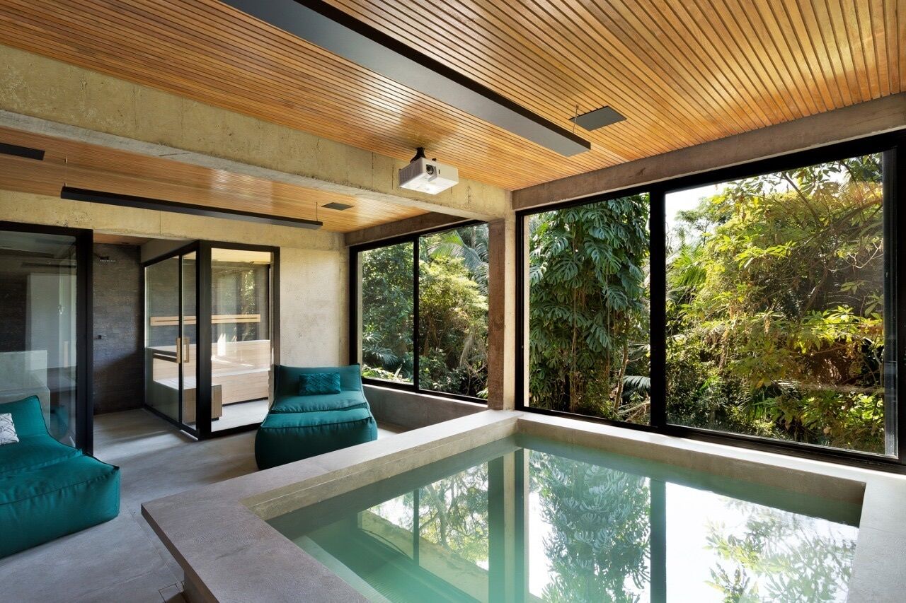 A modern interior with a pool, large windows, and a ceiling with wooden slats.