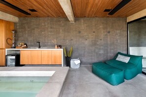 Una cocina moderna con salpicadero de hormigón, armarios de madera y un lavamanos empotrado.