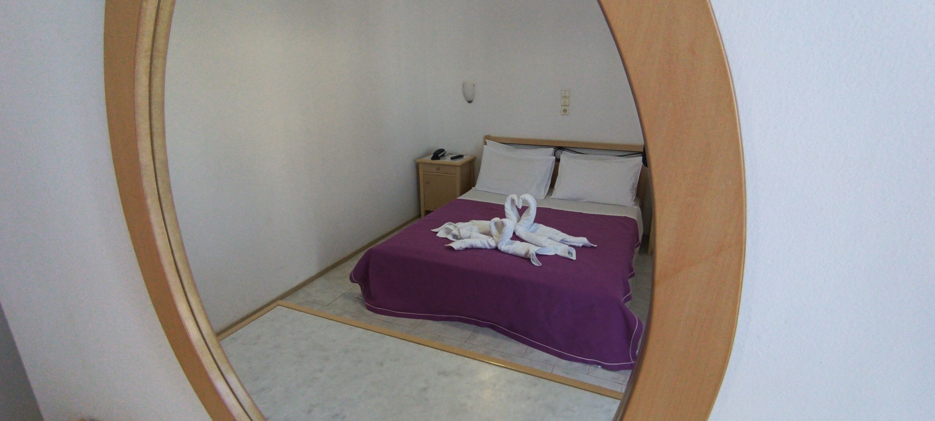 Ein Zimmer mit einem Bett, einem Nachttisch und einer Wandleuchte.