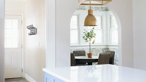 A kitchen with a white countertop, a hanging pendant light, and a potted plant. - The Doctor's Cottage -- 1 mile from Prisma Hospital, 2 miles from Downtown GVL (Greenville)