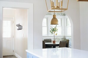 A kitchen with a white countertop, a hanging pendant light, and a potted plant. - The Doctor's Cottage -- 1 mile from Prisma Hospital, 2 miles from Downtown GVL (Greenville)