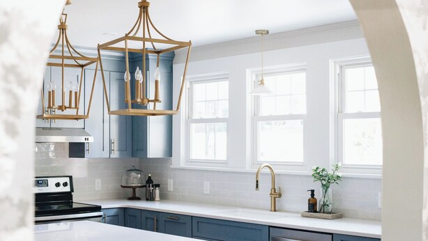 A modern kitchen with blue cabinets, white countertops, a central island, and pendant lighting. - The Doctor's Cottage -- 1 mile from Prisma Hospital, 2 miles from Downtown GVL (Greenville)