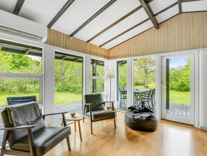Une pièce spacieuse avec de grandes fenêtres, un plafond en bois et une vue sur l’extérieur.