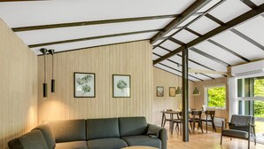 A modern interior with a sectional sofa, a round coffee table, and framed botanical prints on the wall. - "Julika" - 560m from the sea by Interhome (Sæby)